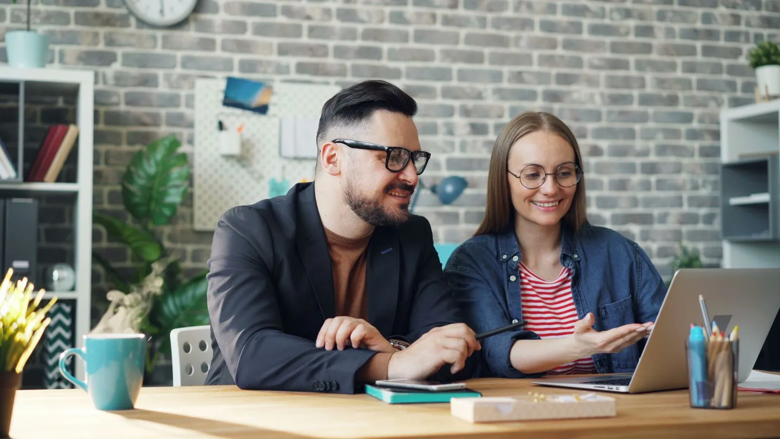 A planner and a client talking over a laptop at a desk